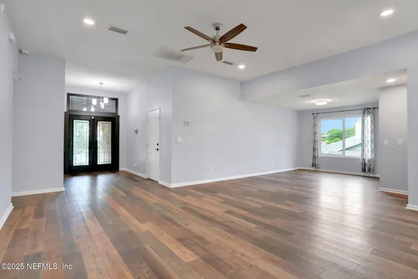 an empty room with window and wooden floor