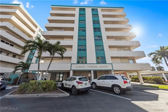 a view of parking with cars parked in front of it