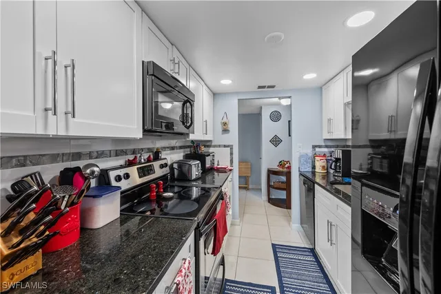 a kitchen with stainless steel appliances granite countertop a refrigerator stove and sink