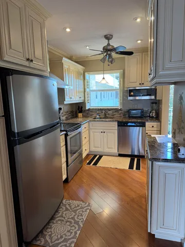 a kitchen with granite countertop stainless steel appliances and wooden cabinets