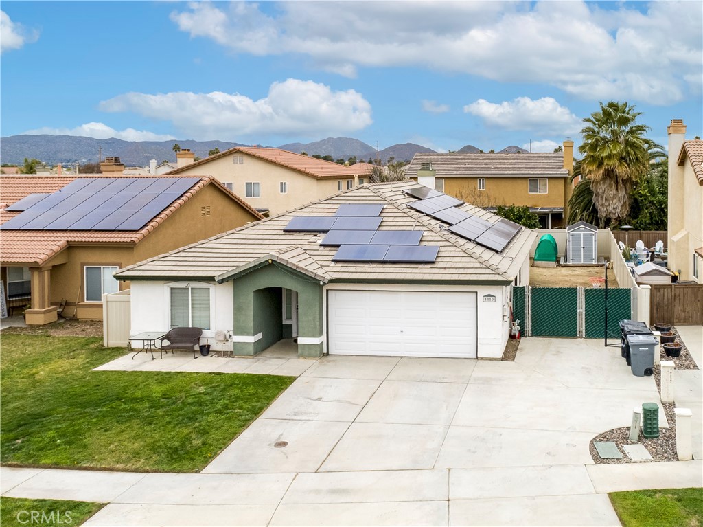 a front view of a house with a garden and mountain view