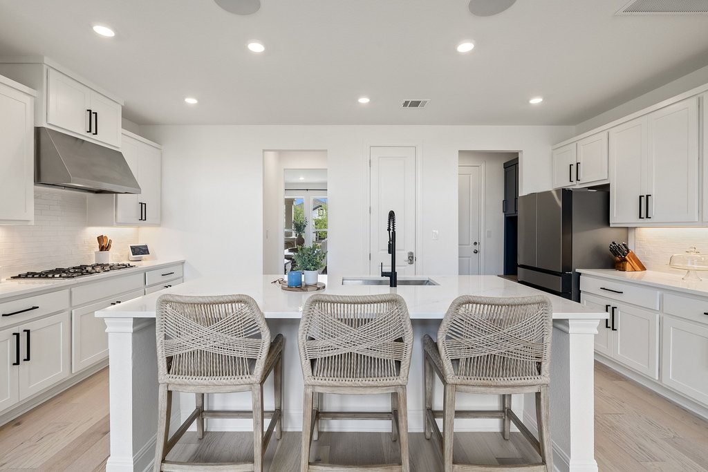 365 Pear Tree Lane Austin, TX 78737 - Photo 14 of 39 a kitchen with stainless steel appliances kitchen island granite countertop a dining table and chairs