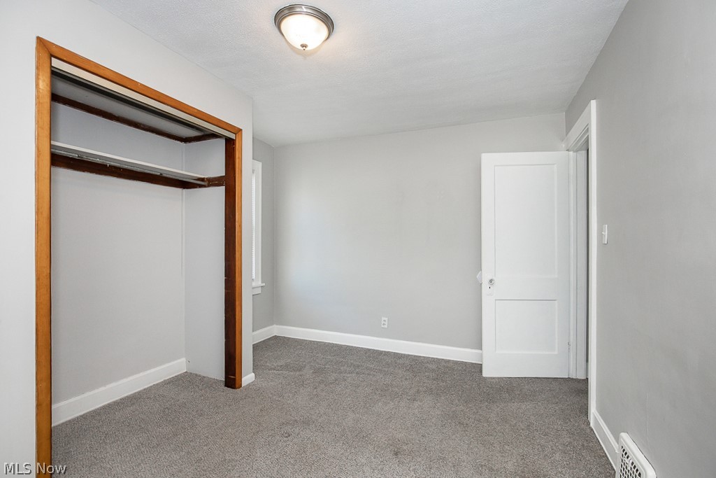 4661 Horton Road Cleveland, OH 44125 - Photo 15 of 27 Unfurnished bedroom featuring a closet and dark carpet