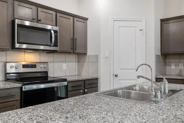 a kitchen with a sink stove and microwave