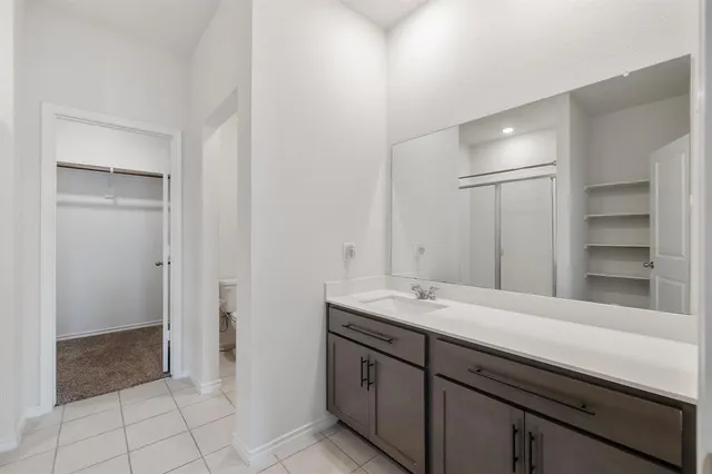 a spacious bathroom with a shower sink and mirror