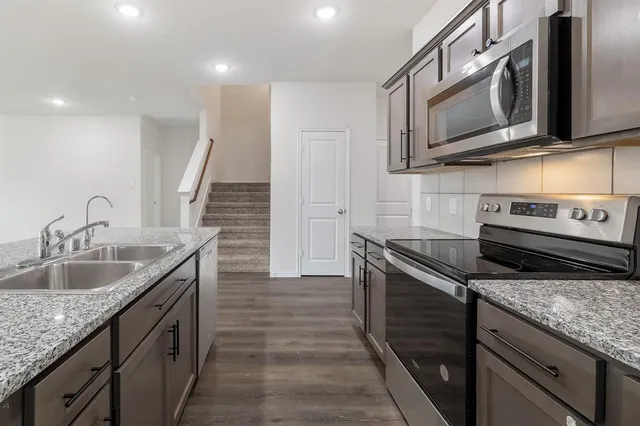 a kitchen with stainless steel appliances granite countertop a sink and stove top oven