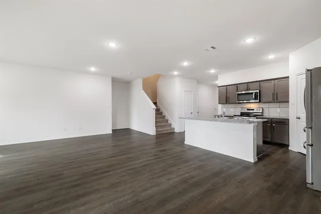 a kitchen with a refrigerator and a stove top oven