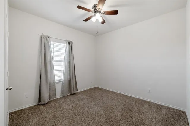 an empty room with closet and windows