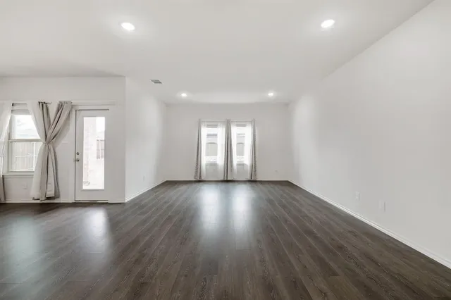 an empty room with wooden floor and window