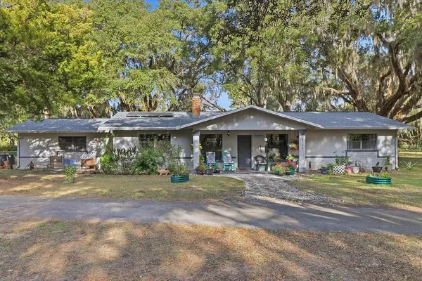 a front view of a building with a garden and seating space
