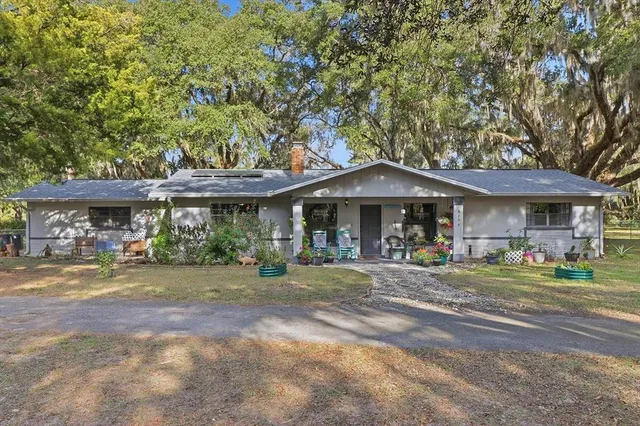 a front view of a building with a garden and seating space