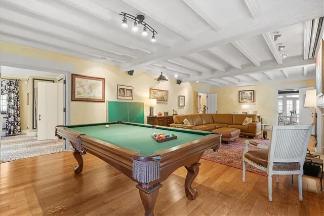 a room with furniture pool table and wooden floor