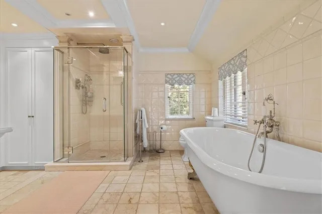 a spacious bathroom with a tub shower and windows