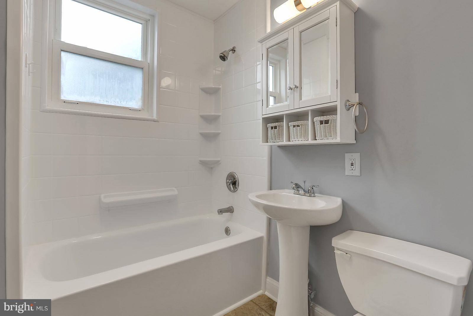 6406 Sherwood Road Baltimore, MD 21239 - Photo 12 of 25 a bathroom with a sink a toilet and a bathtub