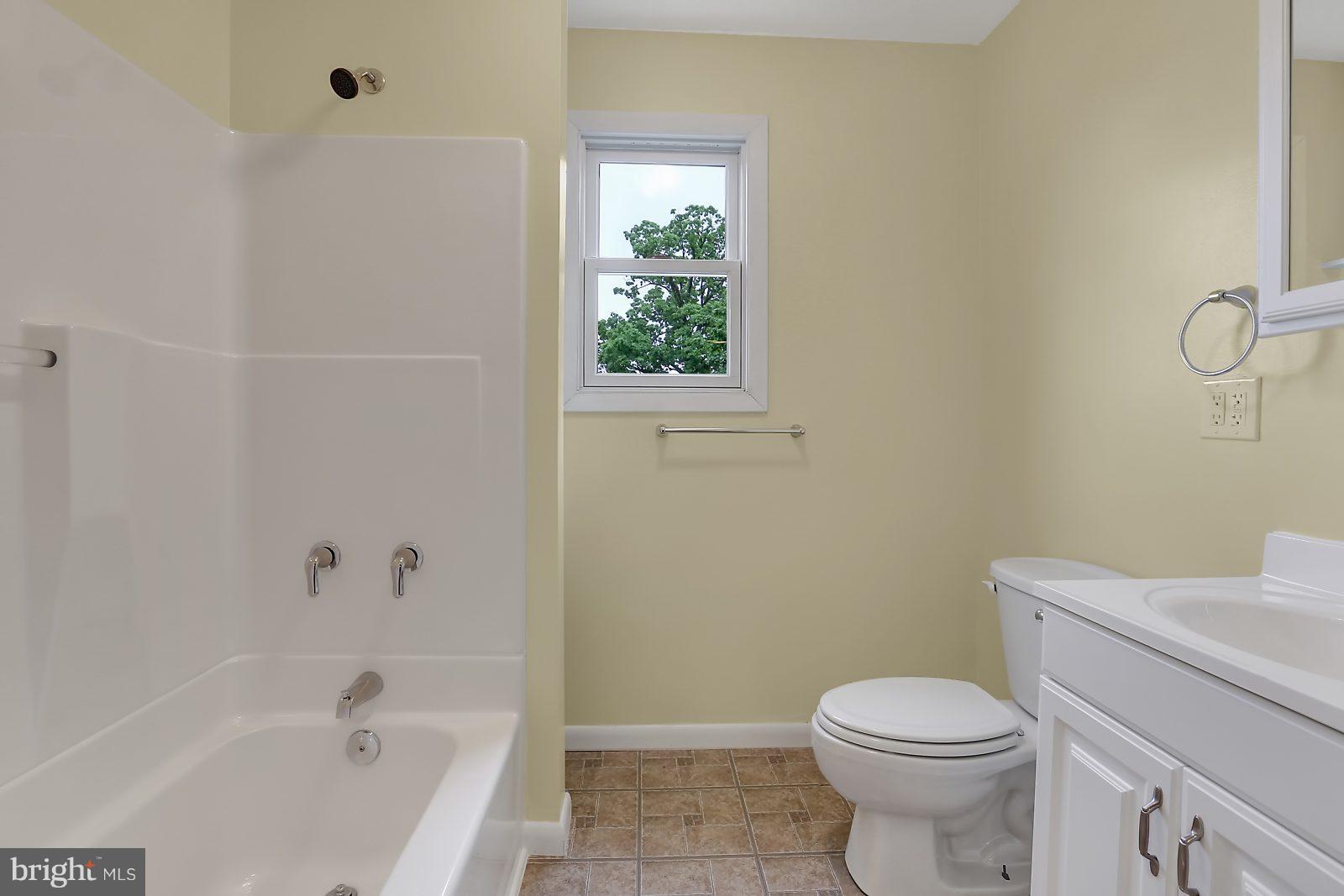 6406 Sherwood Road Baltimore, MD 21239 - Photo 15 of 25 a white toilet sitting next to a bath tub