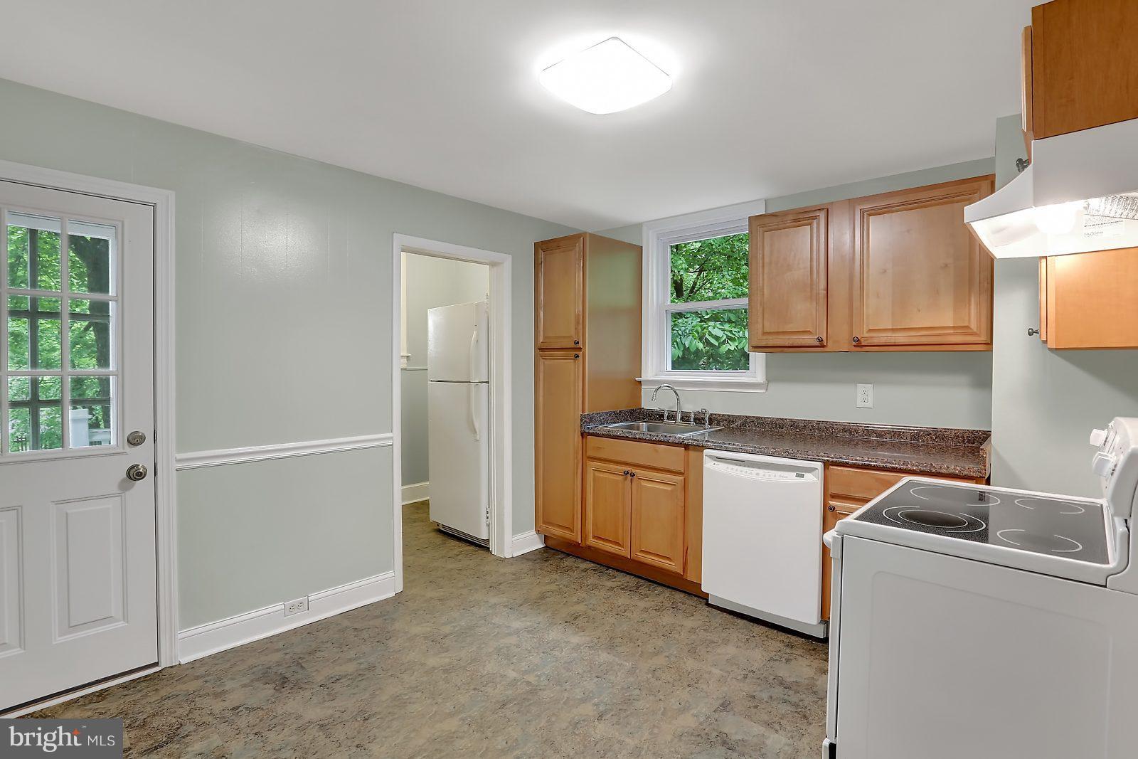 6406 Sherwood Road Baltimore, MD 21239 - Photo 7 of 25 a kitchen with granite countertop a sink and a refrigerator