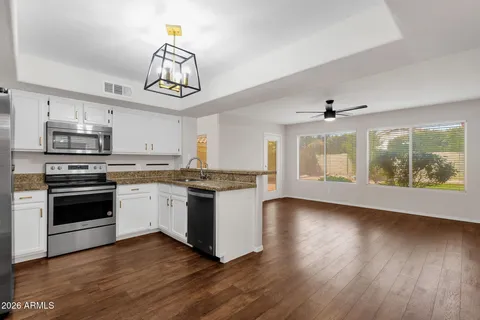 a kitchen with wooden floors and white appliances