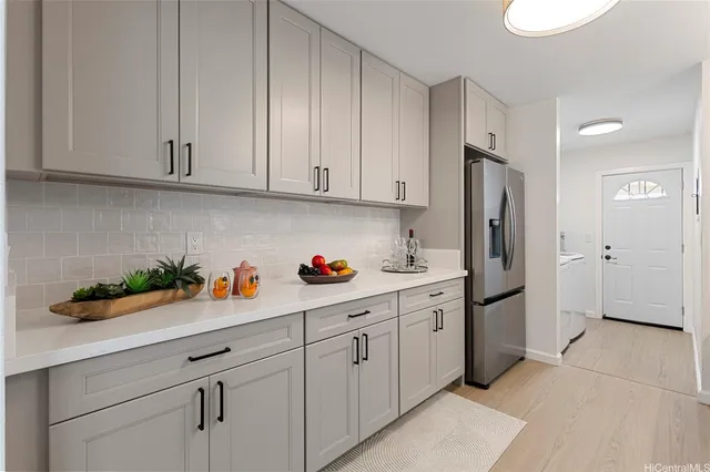 a kitchen with white cabinets and refrigerator
