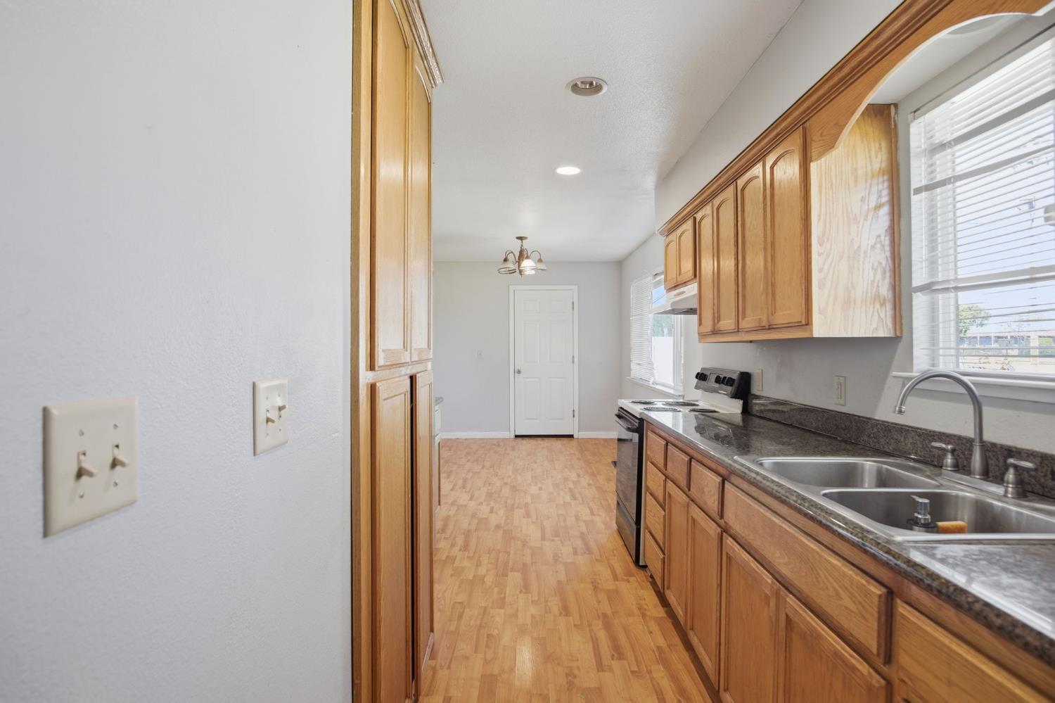 1409 Stonum Road Modesto, CA 95351 - Photo 19 of 40 a kitchen with a sink a refrigerator and window