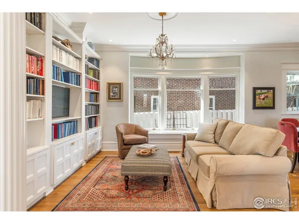 a living room with furniture a chandelier and a large window