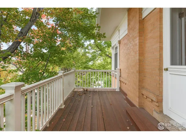 a balcony with wooden floor and yard in back