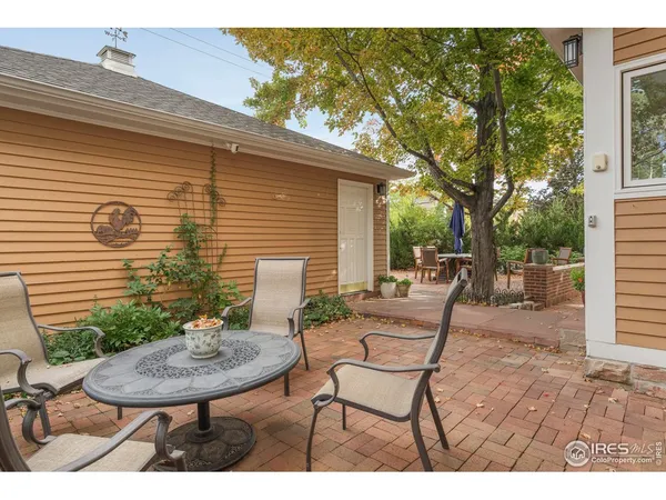 a view of a chair and table in backyard of the house