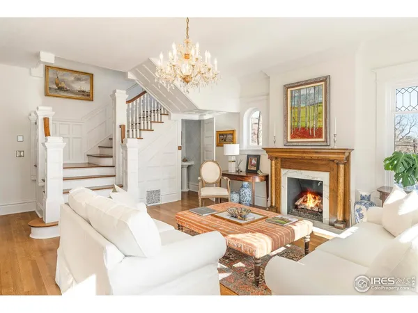 a living room with furniture a fireplace and chandelier