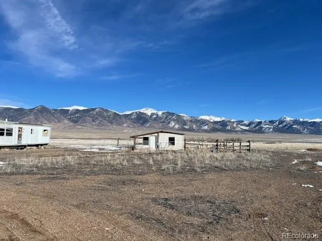 a view of a dry yard with wooden fence