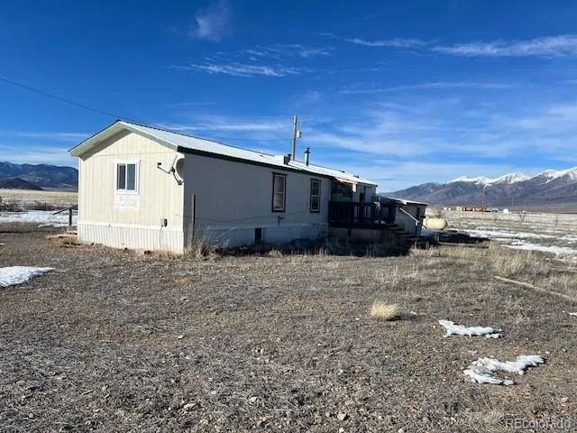 a view of residential houses with yard and mountain view in back