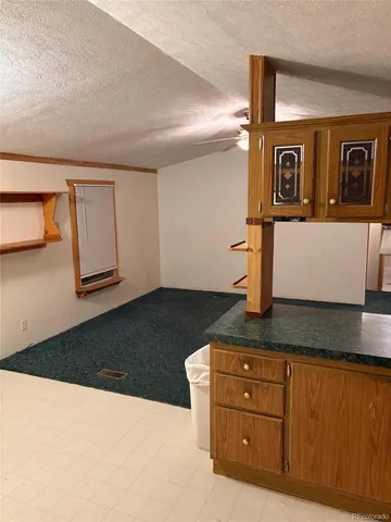 a kitchen with granite countertop a refrigerator and a stove