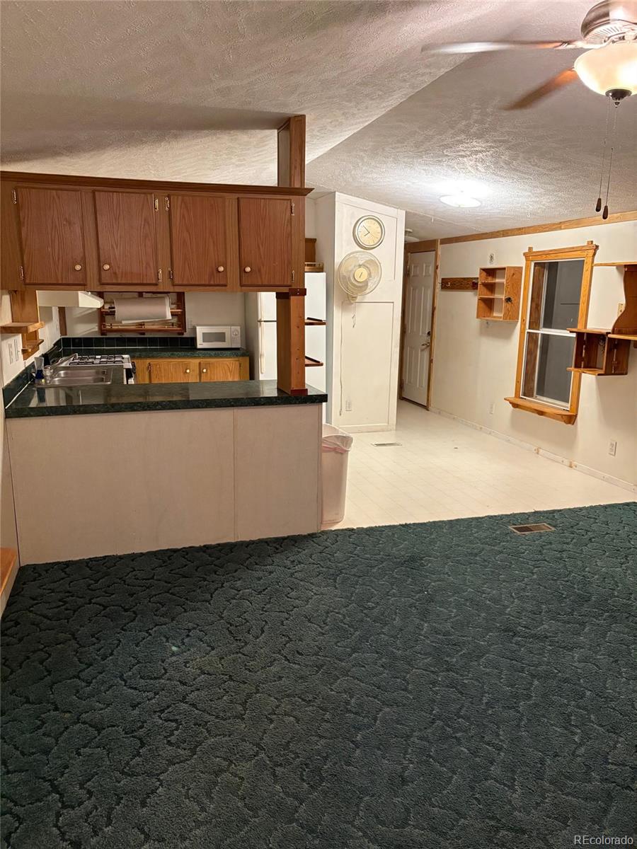 59505 County Rd Gg Moffat, CO 81143 - Photo 8 of 32 a kitchen with granite countertop a refrigerator and a stove