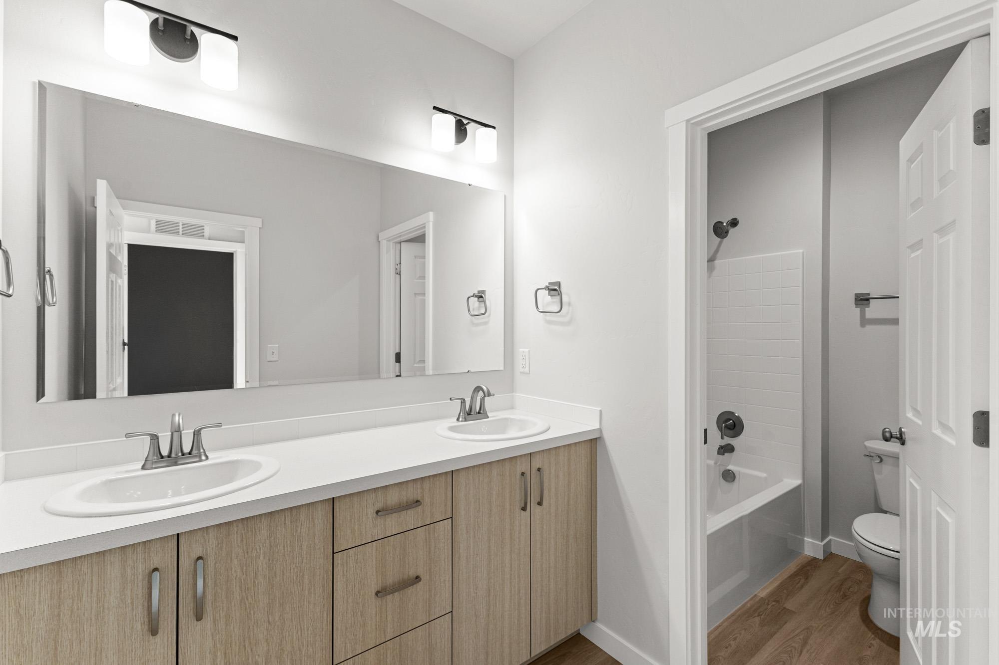 13708 Judson Street Caldwell, ID 83607 - Photo 21 of 29 Full bath featuring shower / bathtub combination, double vanity, and wood finished floors
