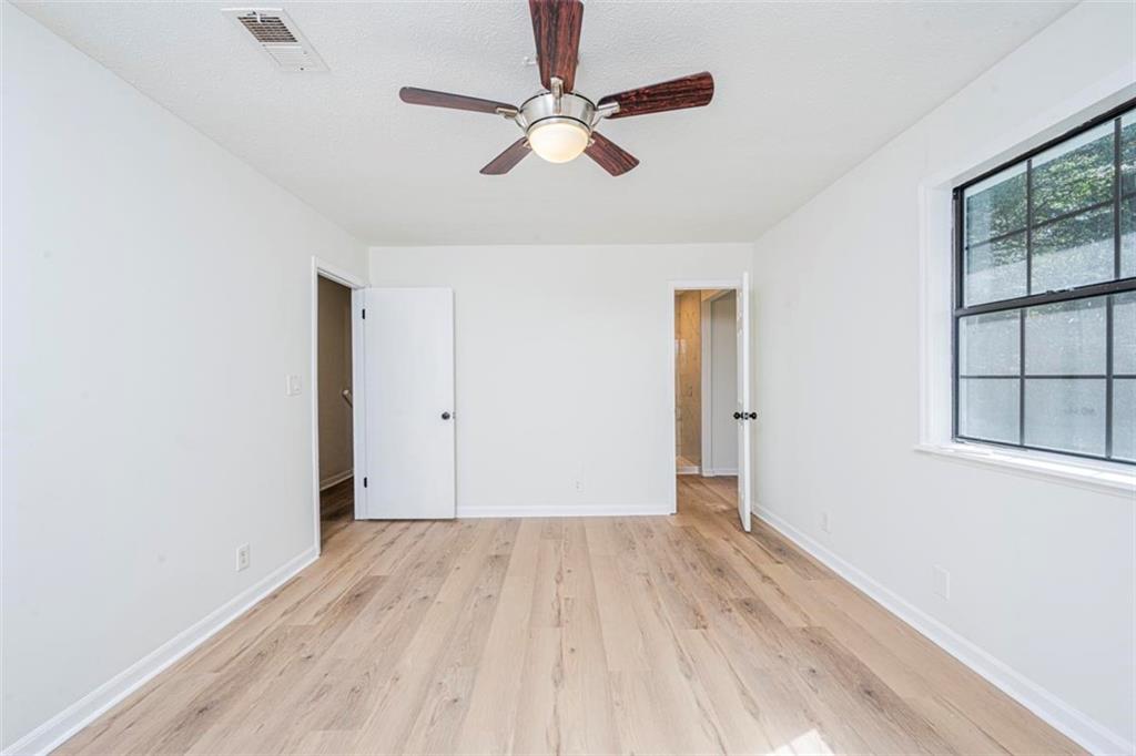 1752 Mitzi Court Duluth, GA 30097 - Photo 7 of 20 an empty room with wooden floor chandelier fan and windows