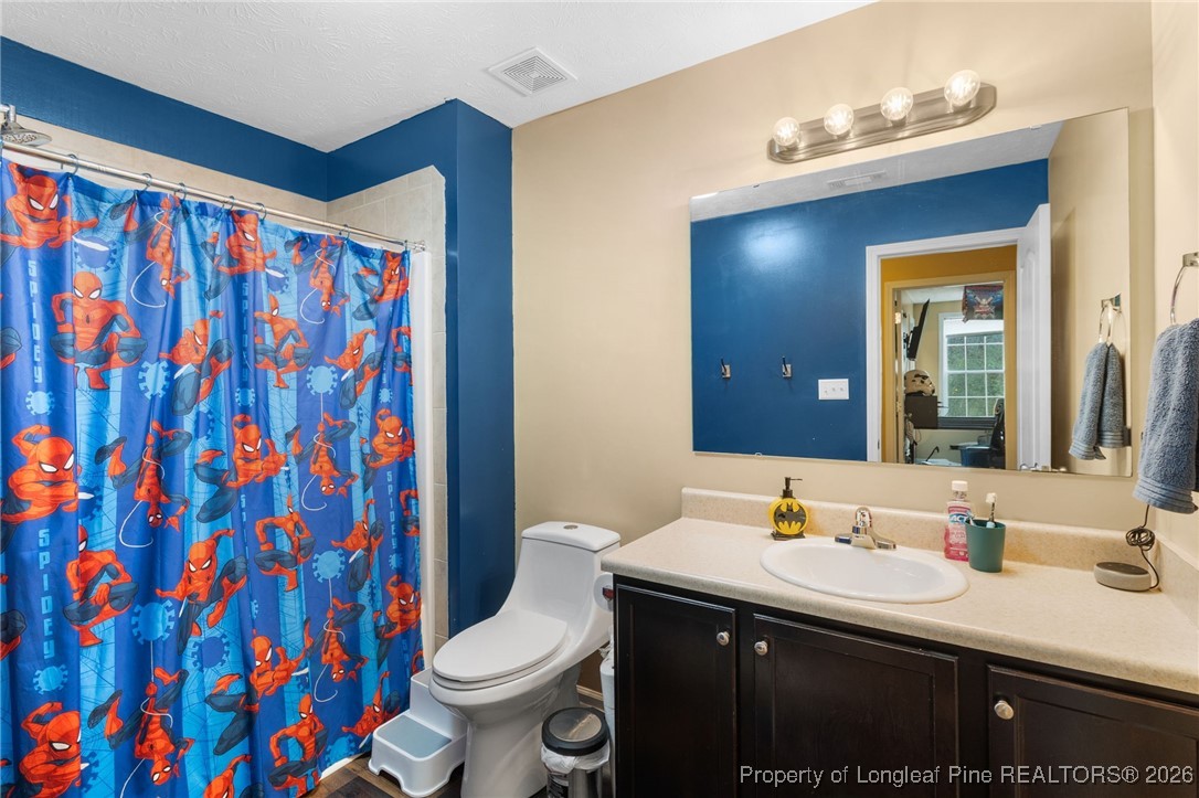 290 Mayor Court Raeford, NC 28376 - Photo 26 of 32 a bathroom with a sink a toilet and shower curtain