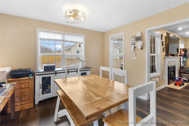 a dining room with wooden floor and stainless steel appliances