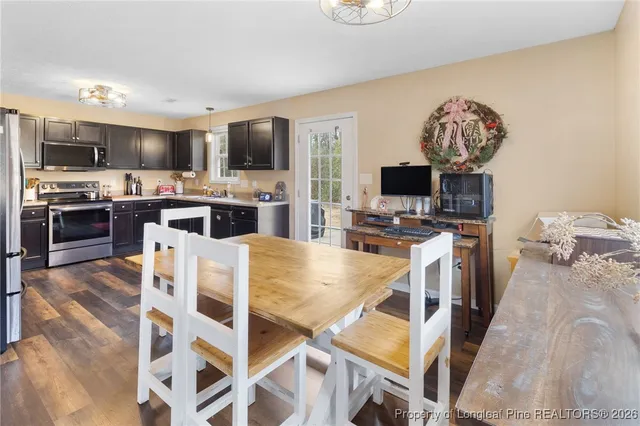 a large kitchen with a table chairs stainless steel appliances and cabinets