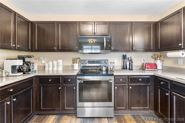 a kitchen with stainless steel appliances granite countertop wooden cabinets a sink and a stove