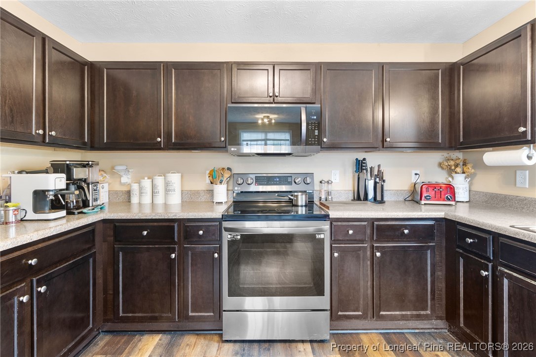 290 Mayor Court Raeford, NC 28376 - Photo 9 of 32 a kitchen with stainless steel appliances granite countertop wooden cabinets a sink and a stove