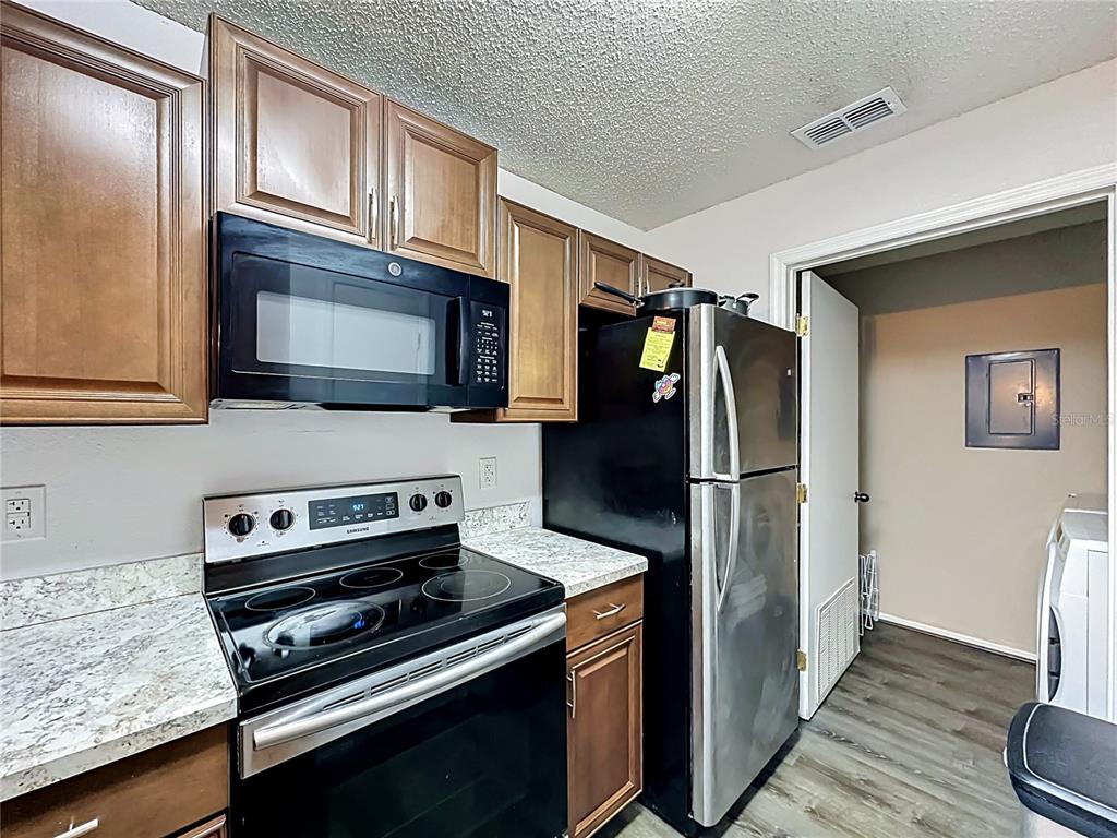 3705 Southwest 27th Street, Unit 922 Gainesville, FL 32608 - Photo 9 of 34 a kitchen with stainless steel appliances and wooden cabinets