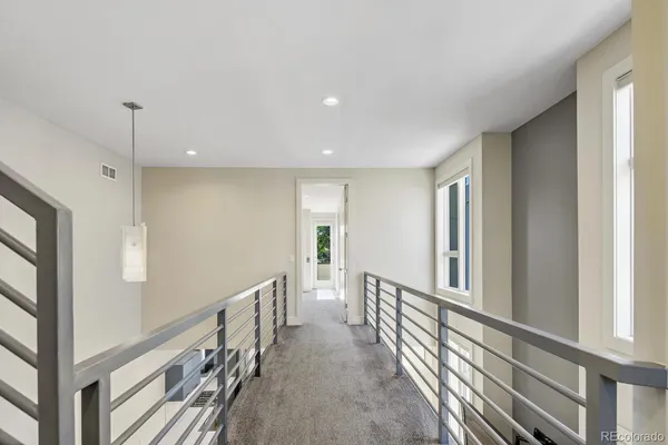 a view of a hallway with wooden floor and staircase