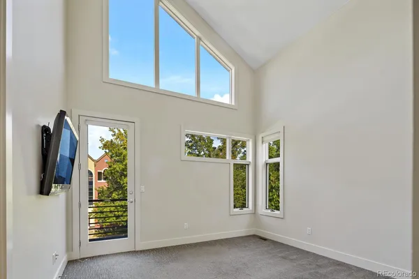 a view of a livingroom with wooden floor and a ceiling fan
