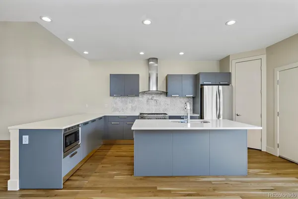 a large kitchen with stainless steel appliances granite countertop a sink a stove and cabinets