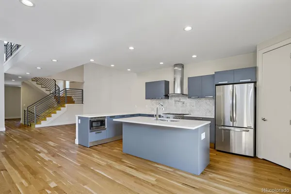 a kitchen with stainless steel appliances granite countertop a sink refrigerator and microwave