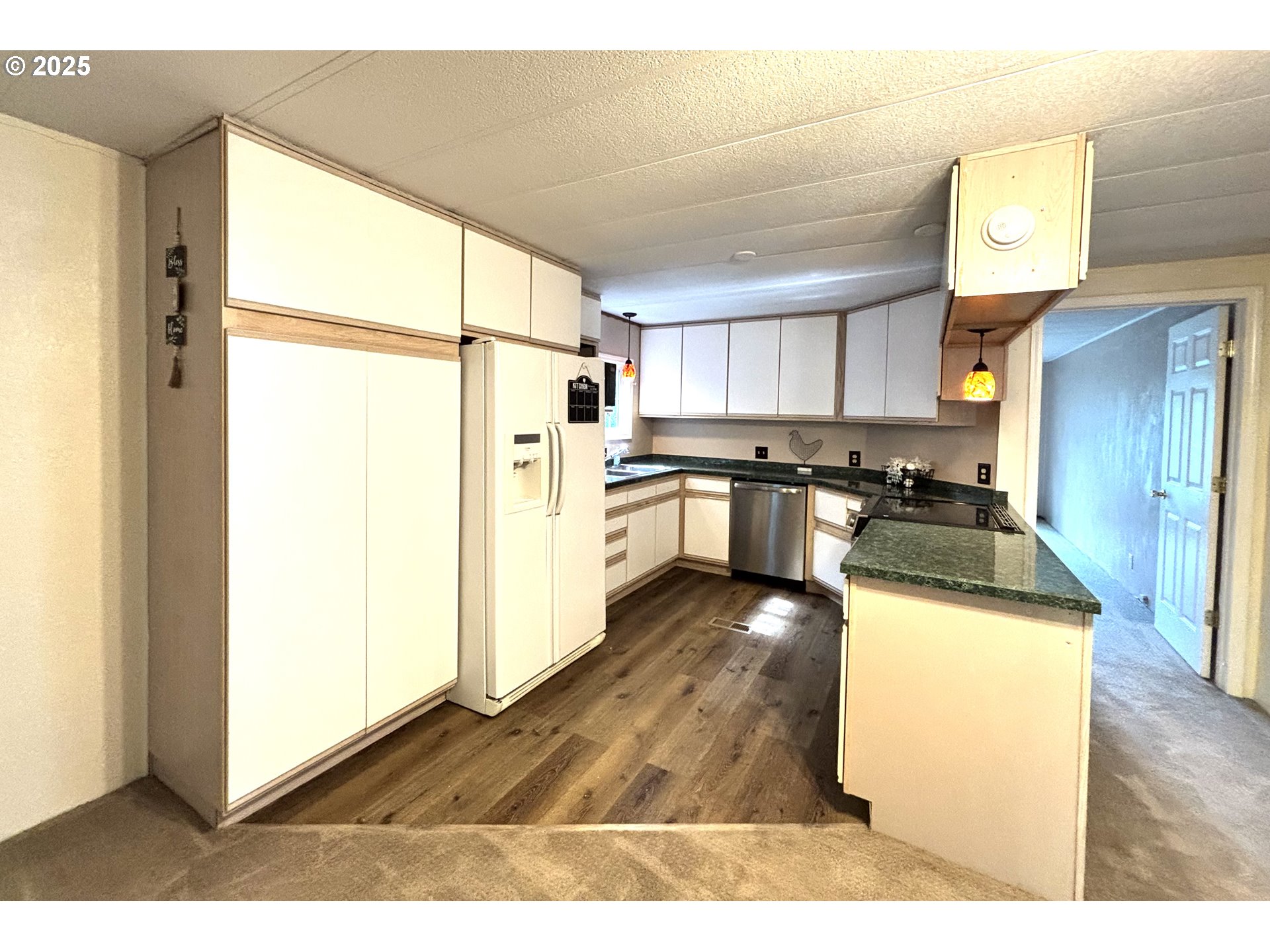 1600 Rhododendron Drive, Unit 29 Florence, OR 97439 - Photo 13 of 35 a kitchen with stainless steel appliances granite countertop a refrigerator a stove and a sink with wooden floor