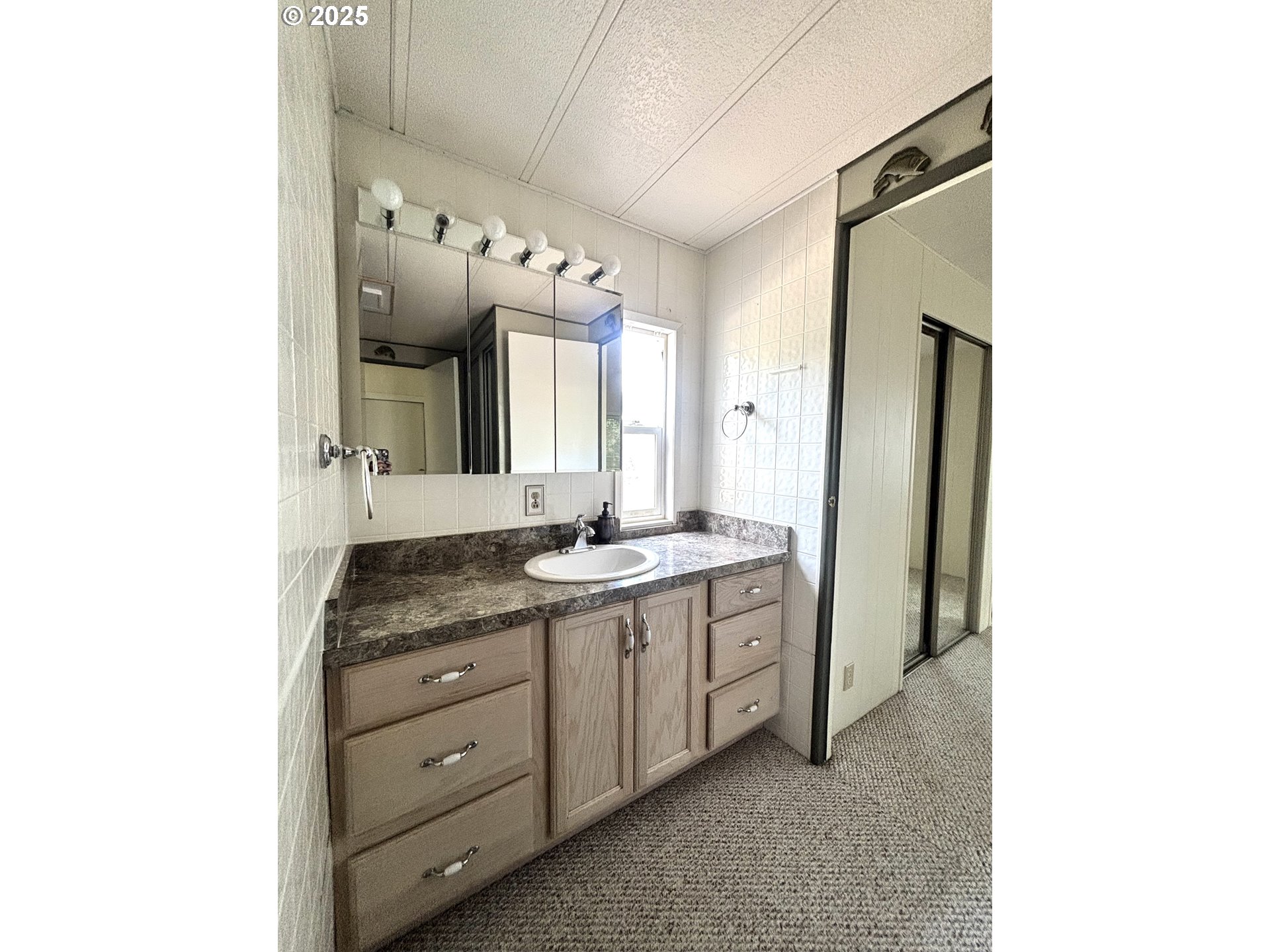1600 Rhododendron Drive, Unit 29 Florence, OR 97439 - Photo 25 of 35 a spacious bathroom with a granite countertop sink and a mirror