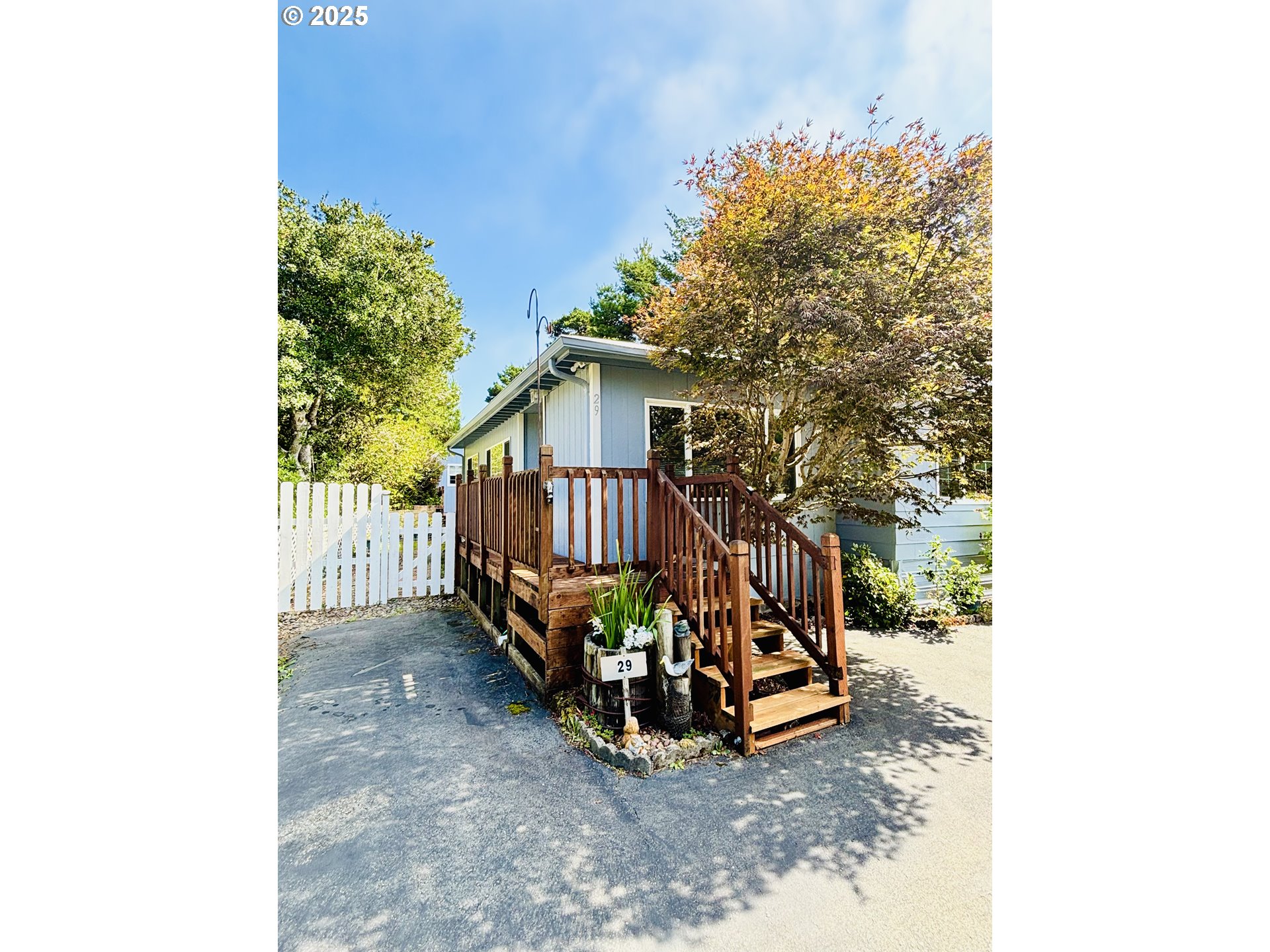 1600 Rhododendron Drive, Unit 29 Florence, OR 97439 - Photo 3 of 35 a view of a small yard with wooden fence and a bench