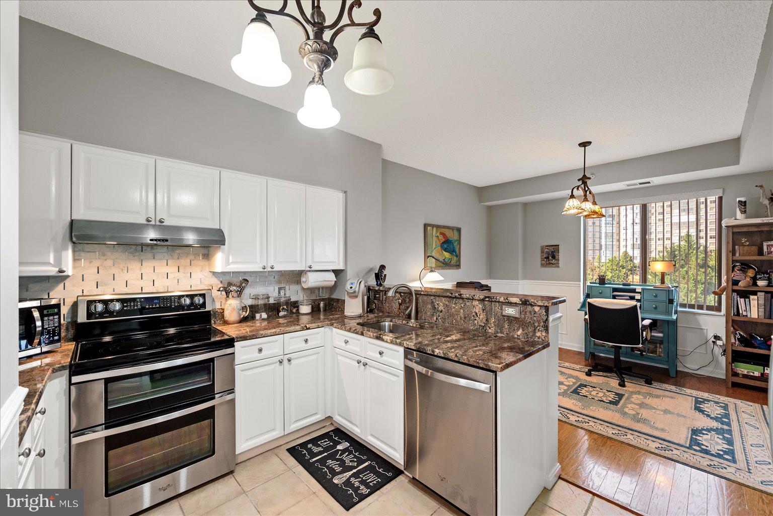 19375 Cypress Ridge Terrace, Unit 207 Leesburg, VA 20176 - Photo 13 of 44 a kitchen with stainless steel appliances a stove a sink a refrigerator and cabinets