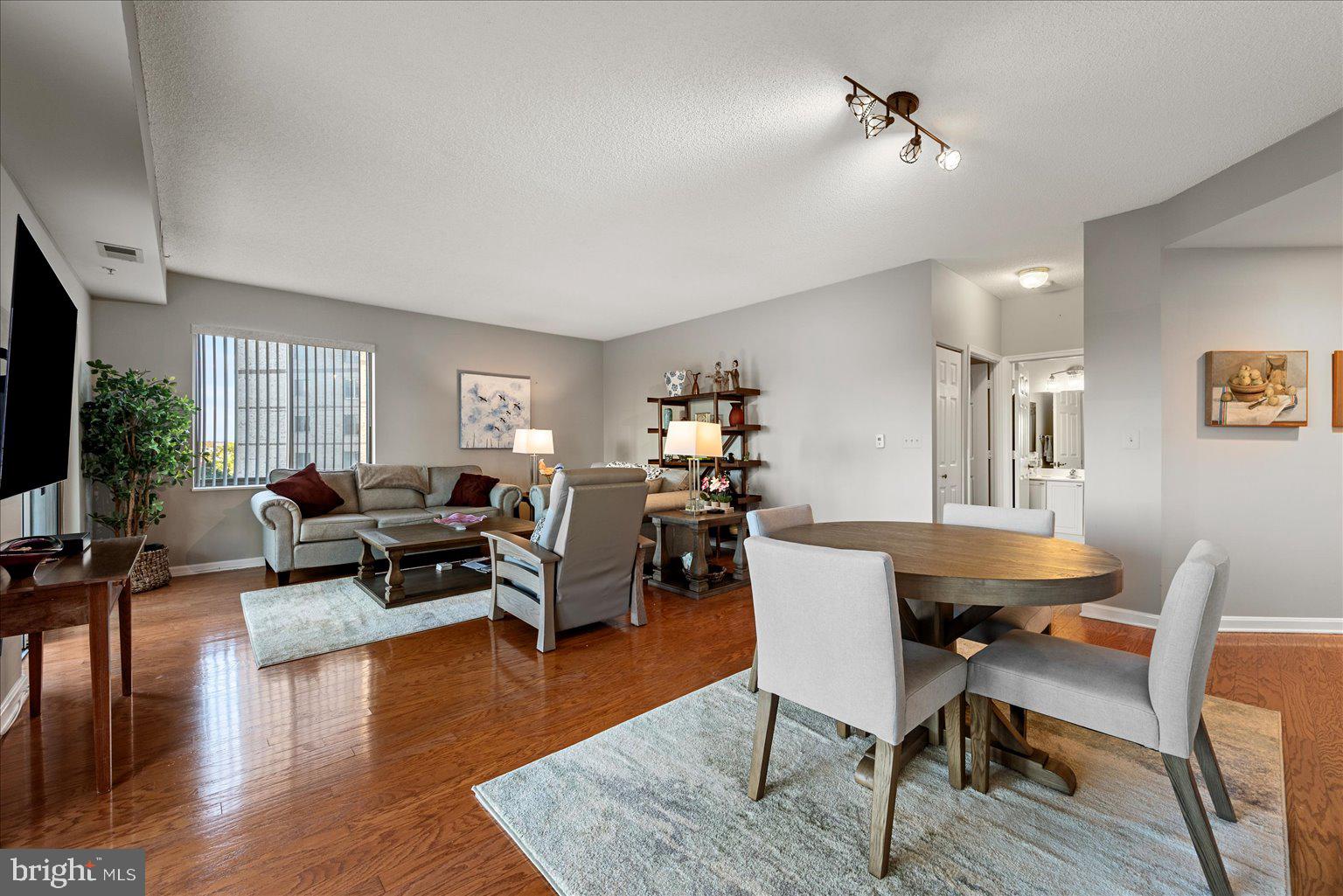 19375 Cypress Ridge Terrace, Unit 207 Leesburg, VA 20176 - Photo 9 of 44 a living room with furniture a wooden floor and a flat screen tv