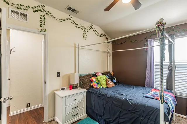 a bedroom with a bed and a flat tv screen on the dresser