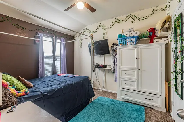a bedroom with a bed chandelier and a large window